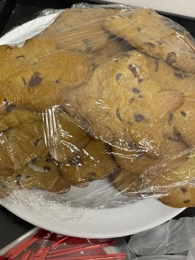 A plate holds a collection of cookies, neatly wrapped in plastic, highlighting their delicious appearance