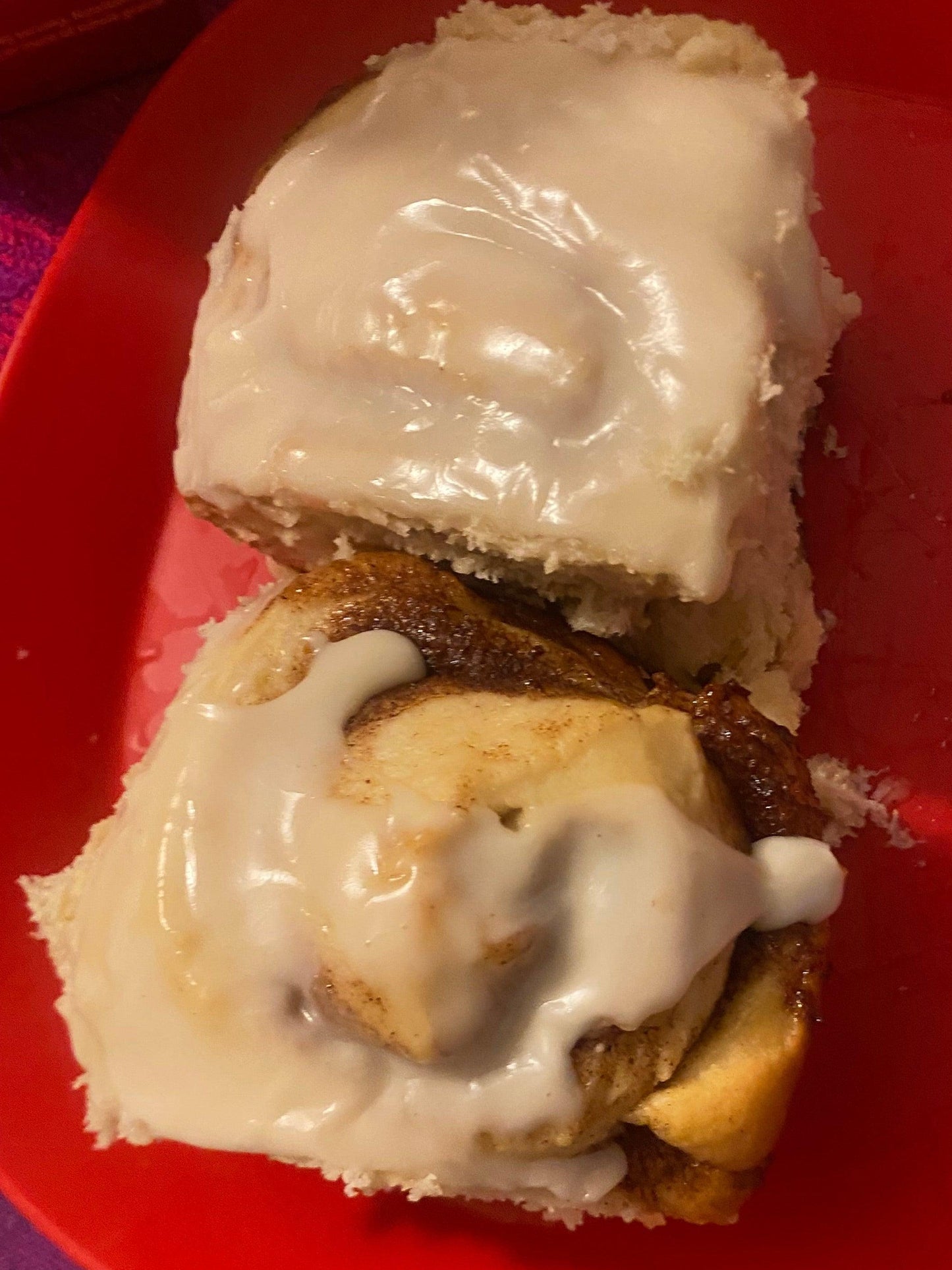 two cinnamon rolls topped with creamy icing, highlighting their delicious, spiral shape