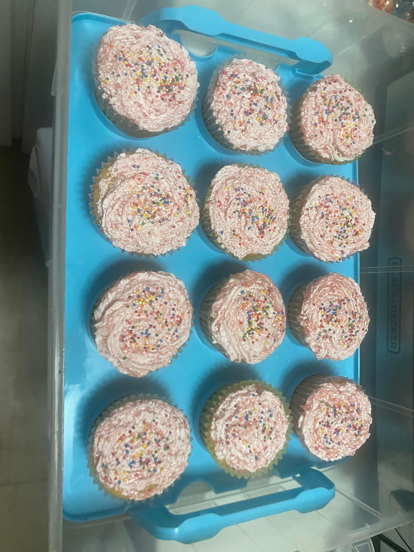 A close-up of several cupcakes with unique designs, showcasing bright colors and various toppings on a decorative stand