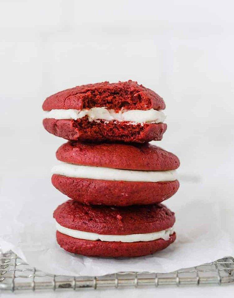 Three stacked red velvet whoopie pies with creamy white filling