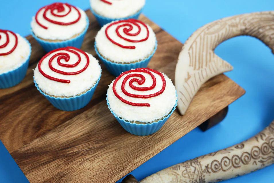 blue-rimmed cupcakes topped with white frosting and red spiral decorations, set against a blue background.